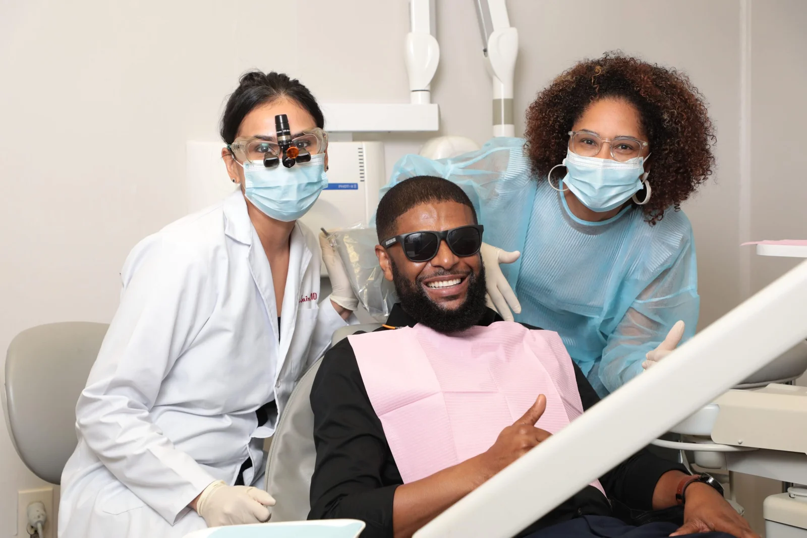 Dr. Jain and team with a smiling patient after successful dental treatment